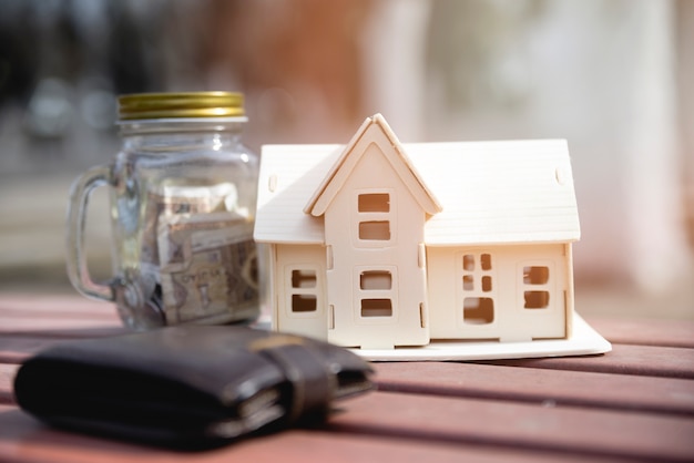 Free photo miniature house with savings jar and wallet