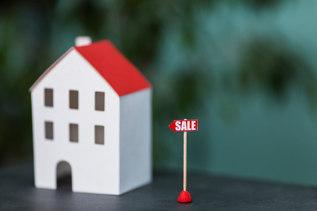 Free photo miniature model of house real estate for sale against blurred backdrop