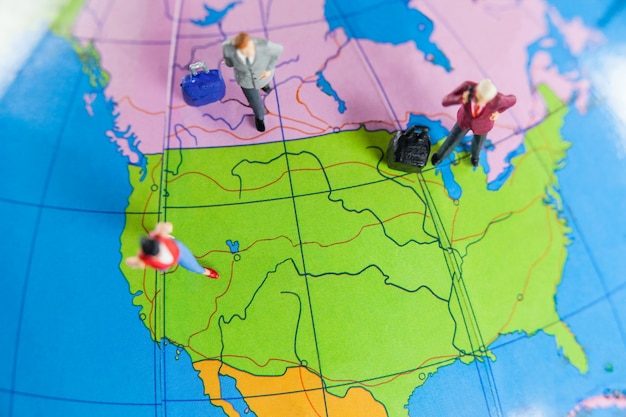 Miniature people travelling on globe