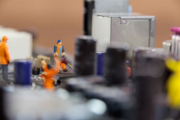 Free Photo miniature workers working on chip of motherboard