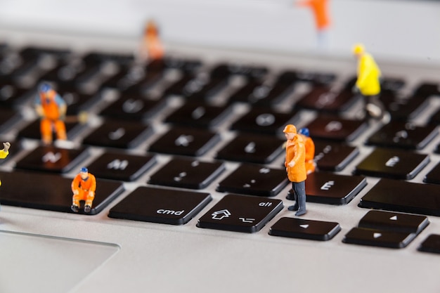 Free Photo miniature workmen repairing a laptop keyboard