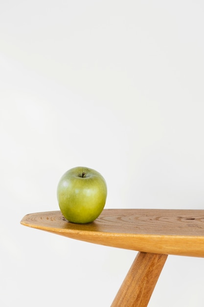 Free Photo minimal abstract concept apple on table front view