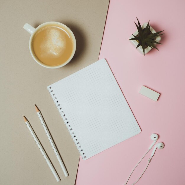 Minimal home desk workspace with clipboard pen coffee mug on pastel pink and grey background Flat lay top view