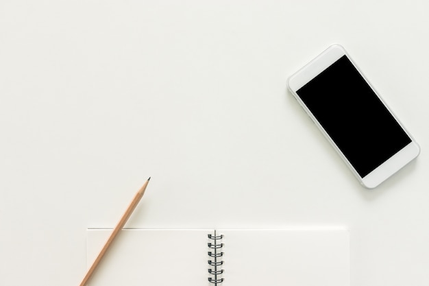 Minimal work space - Creative flat lay photo of workspace desk with sketchbook and mobile phone with blank screen on copy space white background. Top view , flat lay photography.