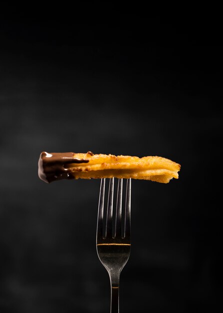 Minimalist fried churros in a fork front view