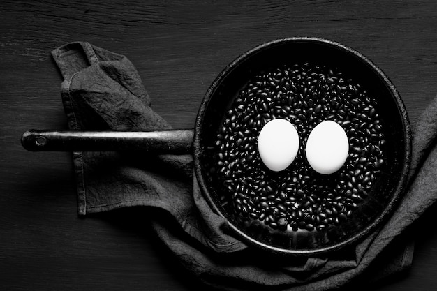 Free photo minimalist frying pan with eggs and seeds