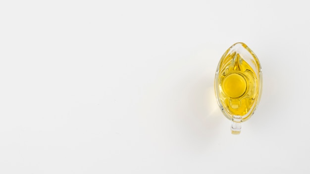 Free photo minimalist olive oil in a glass with white copy space background