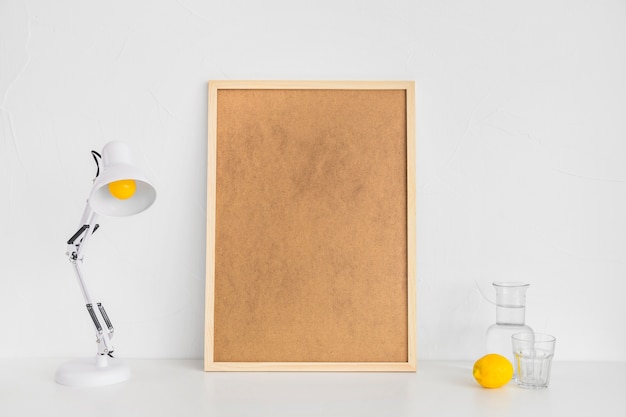 Free photo minimalistic workplace with cork board and lemon