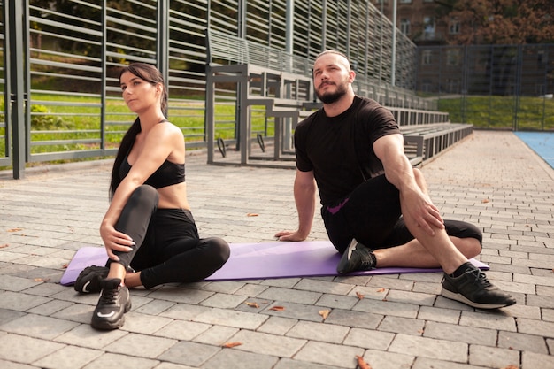 Mirroring yoga exercise on mat with friends 