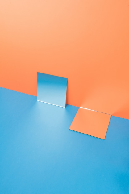 Mirrors on blue table isolated on orange