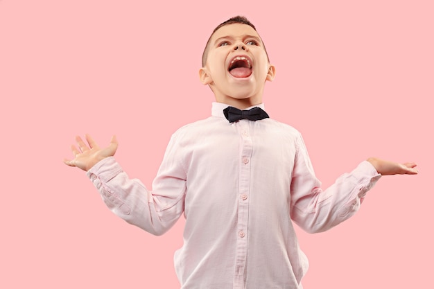 Free photo do not miss. young casual boy shouting. shout. crying emotional teen screaming on pink  space. the male half-length portrait