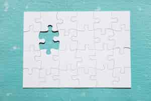 Free photo missing piece of puzzle on blue textured backdrop