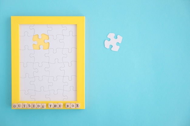 Free photo missing white jigsaw puzzle frame on blue background