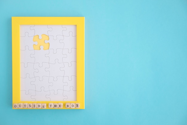 Free Photo missing white jigsaw puzzle yellow frame on blue background