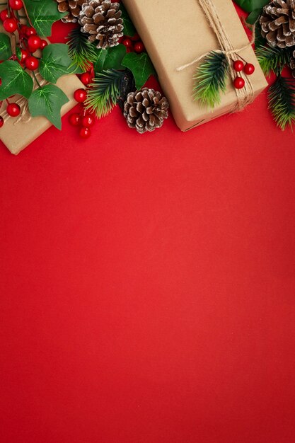 Mistletoe, pine cones and christmas gifts on red table