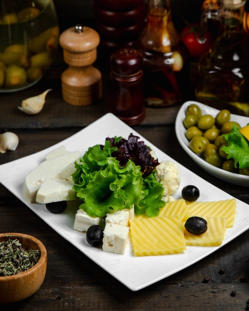 Free Photo mix of cheese served with basil and olives