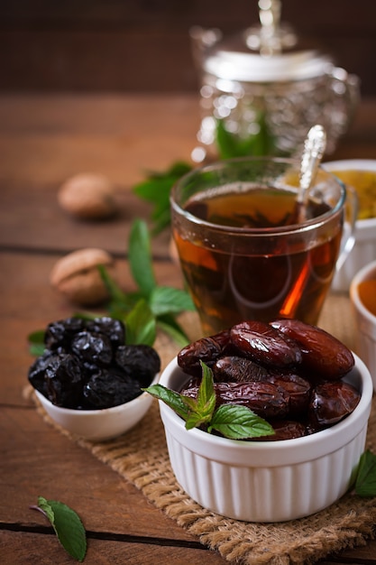 Free photo mix dried fruits (date palm fruits, prunes, dried apricots, raisins) and nuts, and traditional arabic tea. ramadan (ramazan) food.