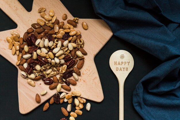 Free photo mix of nuts on cutting board near wood spoon