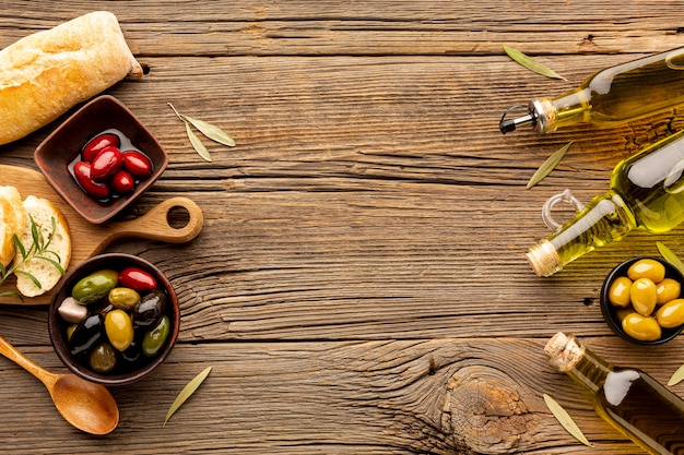 Free photo mix of olives in bowls olive oil bottles and bread with copy space