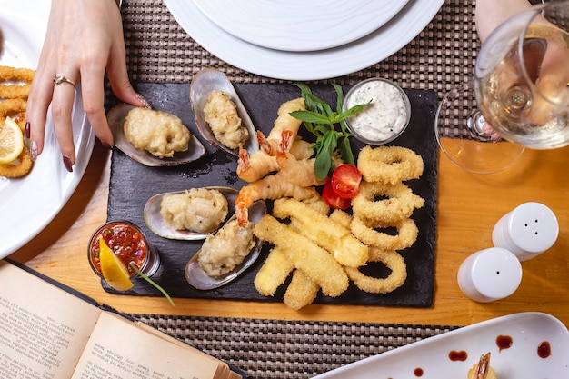 Mix seafood plate calamary prawns mussels lemon tartar sauce tomato mint top view