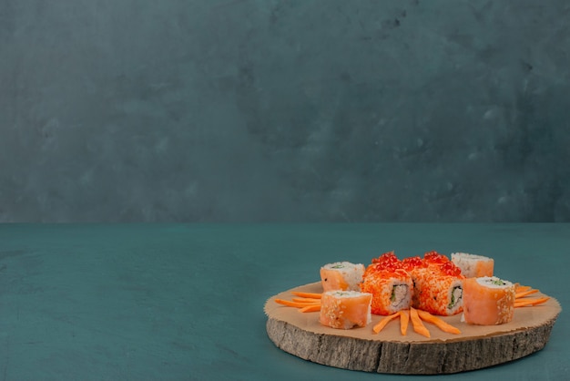 Free Photo mix sushi with carrot slices on wooden board.