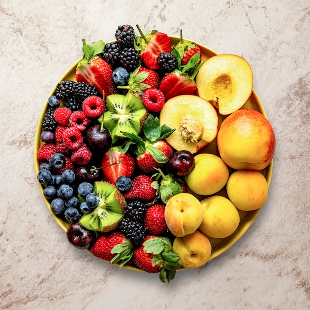 Mixed berries flat lay with peaches and kiwis food photography