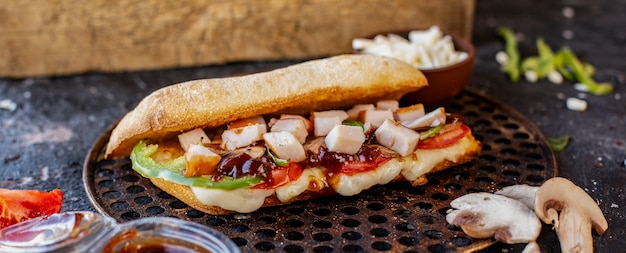 Free photo mixed food doner in baguette bread and feta cheese on a wooden board