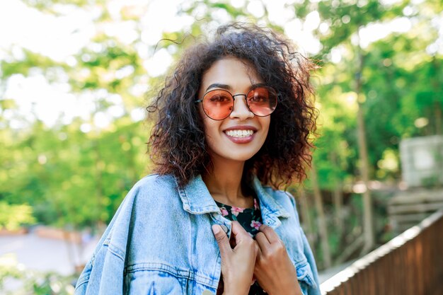 Mixed race  beautiful woman with perfect teeth and hairs spending her leisure in park