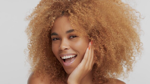 Mixed race black blonde model with curly hair and laughing and put her face on hand