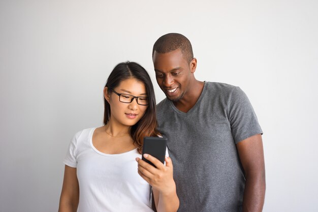 Mixed raced couple of students having video call on phone. 