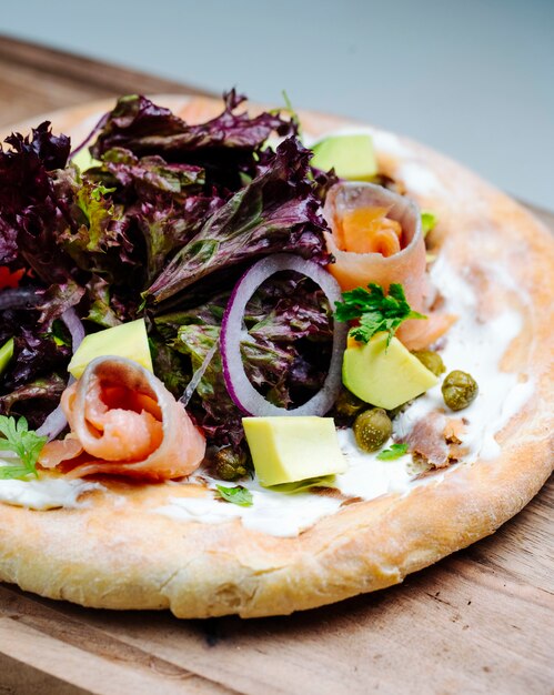 Mixed salad with fish slices served on bread