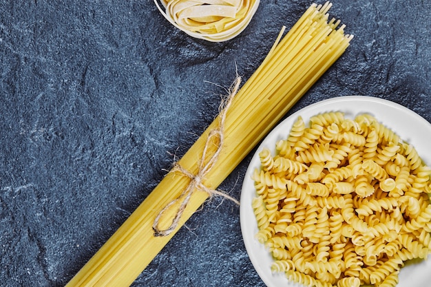 Mixed uncooked pasta on marble.