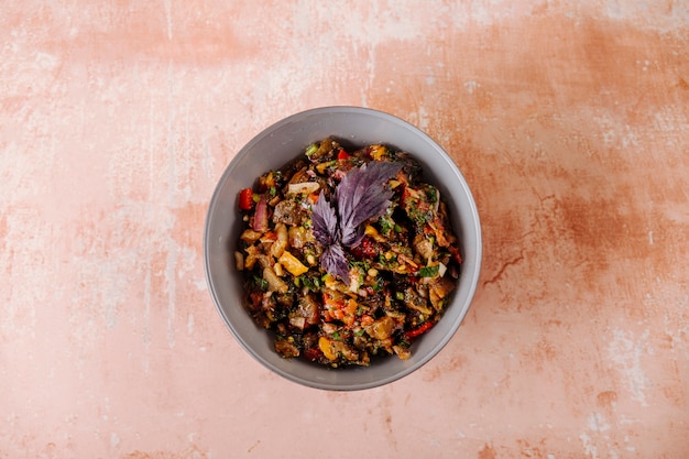 Mixed vegetable salad with red basilic leaf inside bowl.