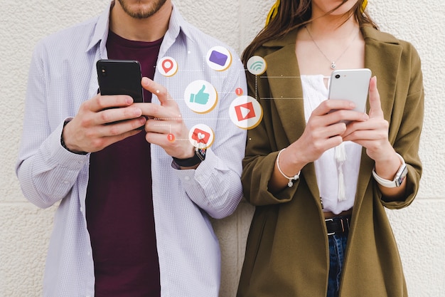 Free photo mobile notification icons between man and woman using cell phone