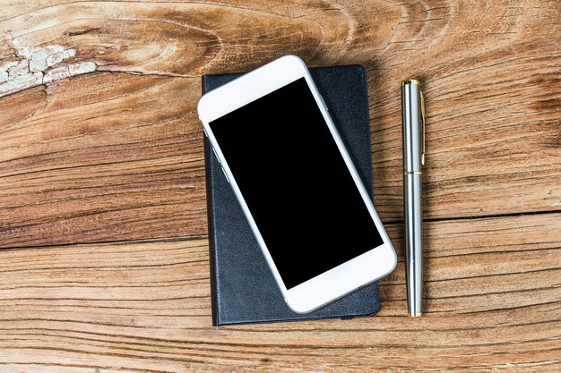 Mobile phone and earphones on wooden background