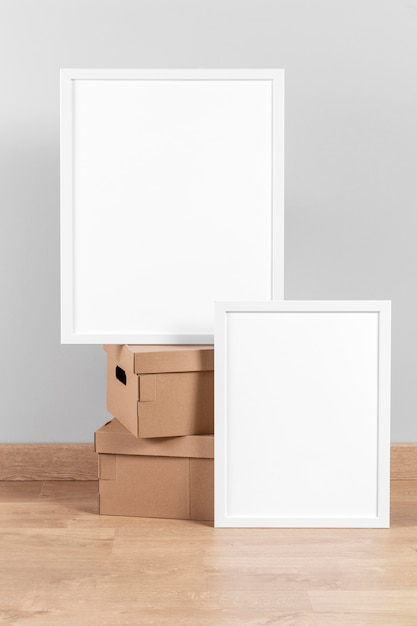 Free photo mock up frames beside cardboard boxes