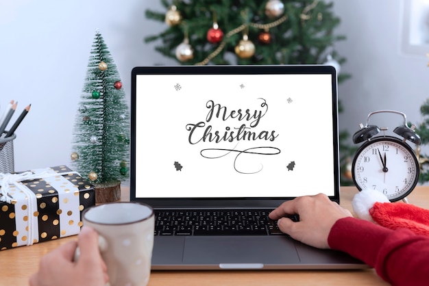 Mockup laptop computer with white screen on office table in christmas day