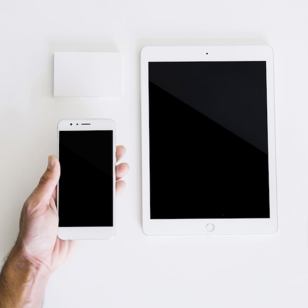 Free photo mockup with hand holding smartphone and tablet