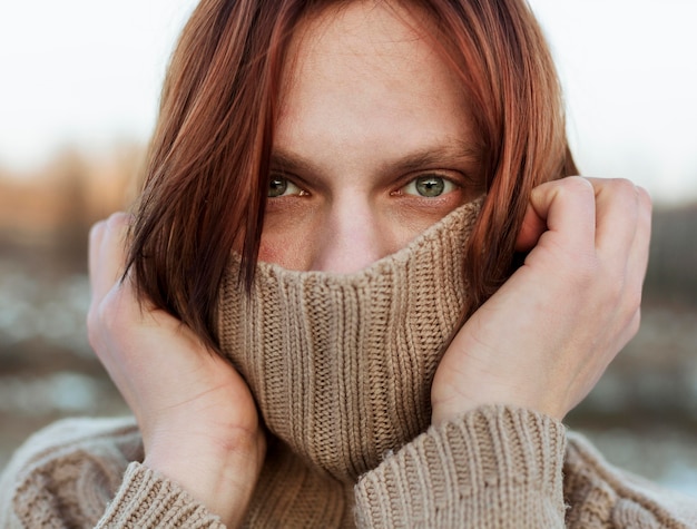 Model covering face with a beige sweater