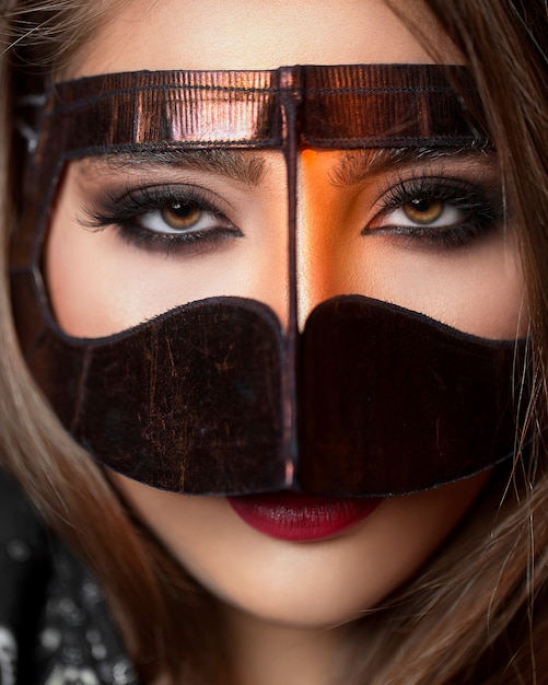 Free photo model in a golden mask accenting her eyes makeup