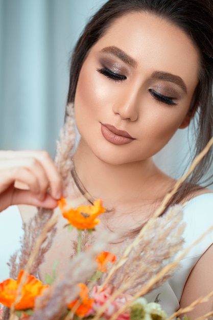 Free Photo model in light makeup holding spring flowers