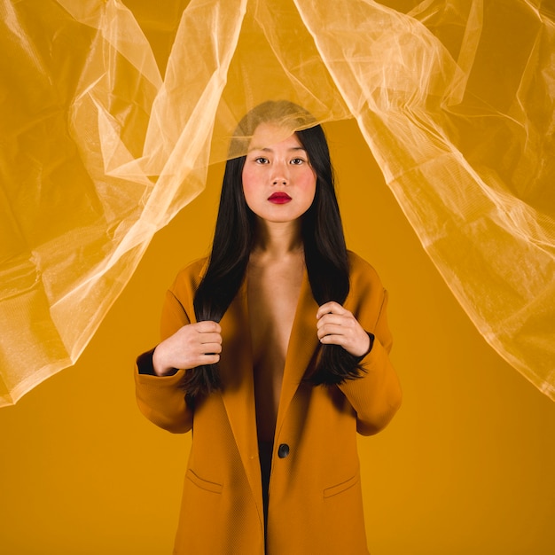 Free Photo model in yellow coat with yellow background 