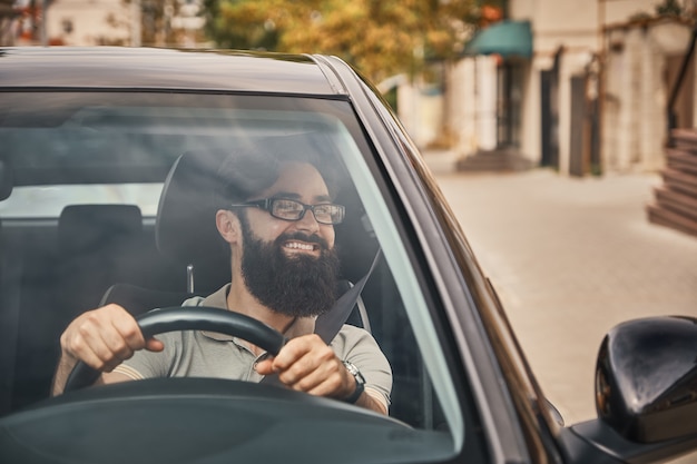 Free photo a modern bearded man driving a car