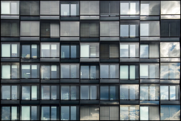 Free photo modern building with glass windows reflecting the beauty of the sky