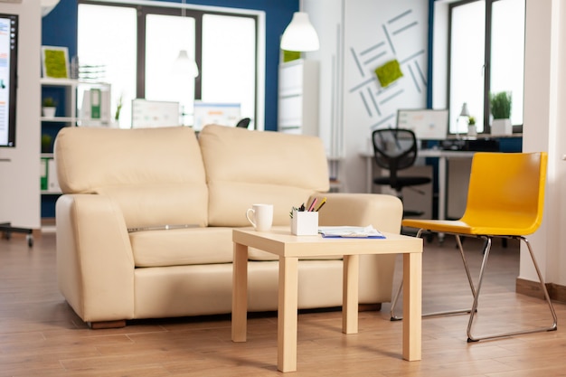 Modern business relax zone interior with confortable couch and orange chair