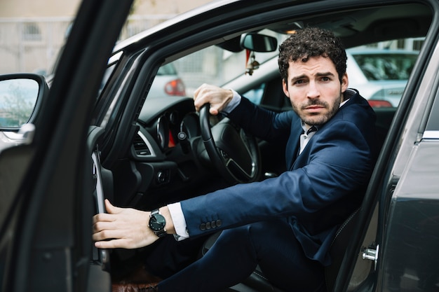 Free photo modern businessman sitting in car