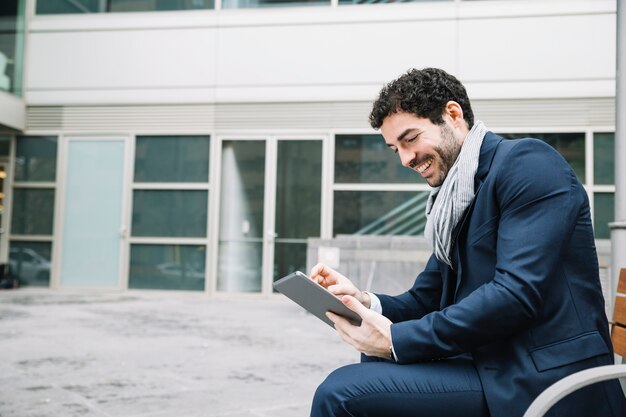 Modern businessman using device outdoors