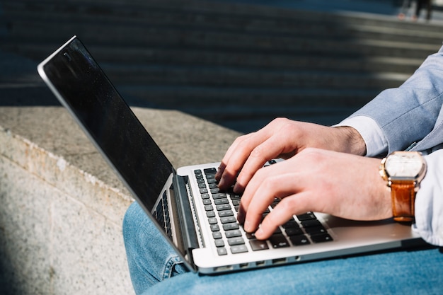 Free photo modern businessman using laptop outdoors