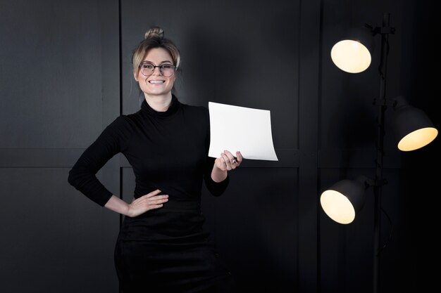 Modern businesswoman holding papers at the office