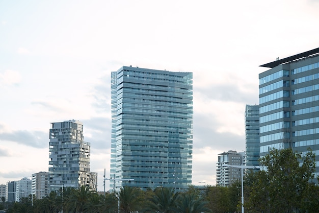 Modern glass and concrete city buildings minutes after sunset against clear white sky